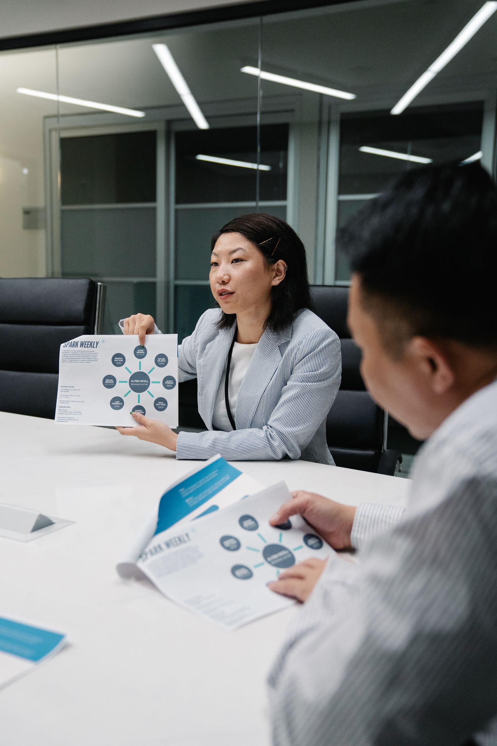 Two professionals reviewing charts at a conference table